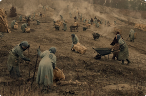 women in long skirts tilling the soil